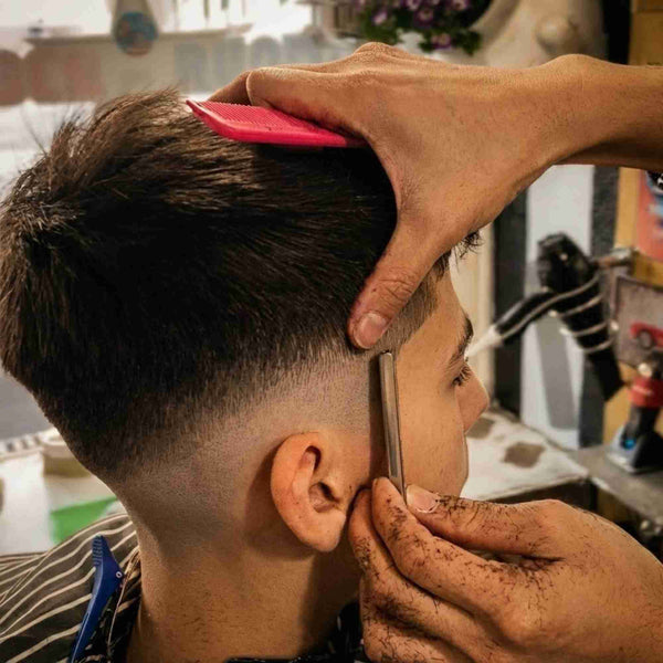 Close up of a barber performing a skin fade and razor lineup at Barber on Hutt Street Adelaide.
