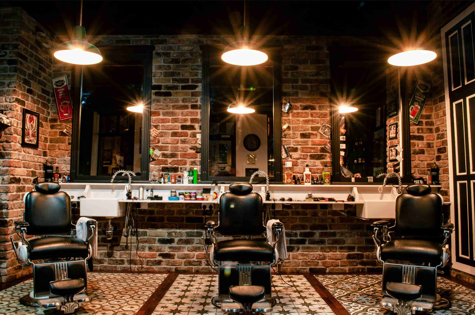 Interior of Barber on Hutt Street featuring classic leather chairs, exposed brick walls, and vintage tiling.